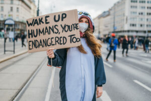 woman with poster - Wake up humans, your'e endagered too 